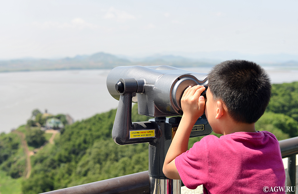 Маленький мальчик смотрит в сторону Северной Кореи со смотровой площадки в демелитаризованной зоне в Южной Корее.